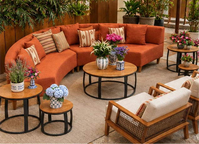 Estudo ilustrativo de lounge social com sofá terracota, mesas redondas e poltronas de madeira